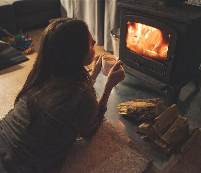 Woman with Hot Cocoa by Fireplace